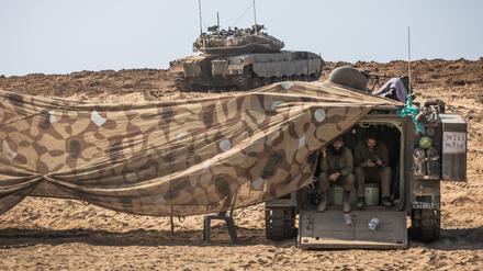 Israelische Soldaten gehen in einem Militärfahrzeug in dem Gebiet in der Nähe des Kibbutz Be’eri in Deckung.