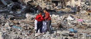 Palästinensische Kinder sammeln Gegenstände in den Trümmern zerstörter Gebäude im Flüchtlingslager Dschabalia am Rande von Gaza-Stadt.