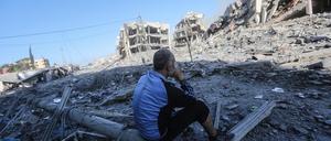 Ein Palästinenser blickt auf zerstörte Gebäude nach einer Bombardierung von Gaza-Stadt.
