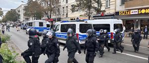 Polizisten laufen angesichts möglicher propalästinensischer Proteste in Berlin-Neukölln über die Straße.