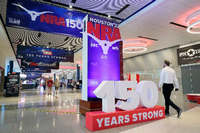 Auf der NRA-Jahrestagung in Houston laufen Besucher in den Ausstellungshallen die Gänge entlang. Foto: Michael Wyke/AP/dpa