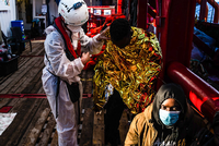 Ein Mitarbeiter des Seenotrettungsschiffs „Ocean Viking“ versorgt gerettete Migranten. Foto: picture alliance/dpa/SOS Mediterranee