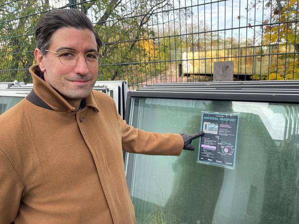 Campus-Manager Selim Güngör mit ausgemusterten Fenster, die mit einem Rohstoffpass versehen wurden, damit sie weiterverwertet werden können.