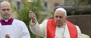 Papst Franziskus (r) segnet die Gläubigen mit Oliven- und Palmzweigen, bevor er die Palmsonntagsmesse auf dem Petersplatz im Vatikan zelebriert, einen Tag nachdem er aus dem Krankenhaus in Rom entlassen wurde, wo er wegen einer Bronchitis behandelt wurde.