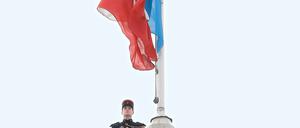 Wachmann hinter der französischen Nationalflagge am Elysee-Palast in Paris