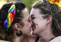 Teilnehmerinnen der jährichen Jerusalem Pride Parade küssen sich. Foto: RONALDO SCHEMIDT / AFP