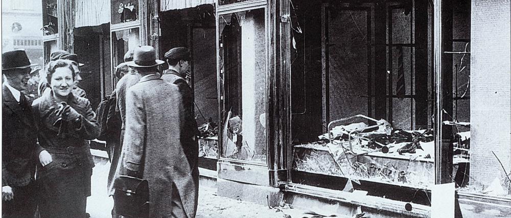 Vor aller Augen. Passanten vor einem zerstörten jüdischen Geschäft im November 1938.