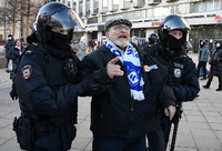 Zwei Uniformierte mit Schutzhelmen führen einen älteren Mann auf einem öffentlichen Platz ab. Foto: AFP/Alexander Nemenov