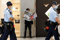Passant in Hongkong mit der letzten Ausgabe der „Apple Daily“ am 24. Juni 2021 Foto: Reuters/Tyrone Siu