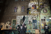 Polizisten steigen über Leitern in das Haus in der Rigaer Straße 94 ein. Foto: dpa