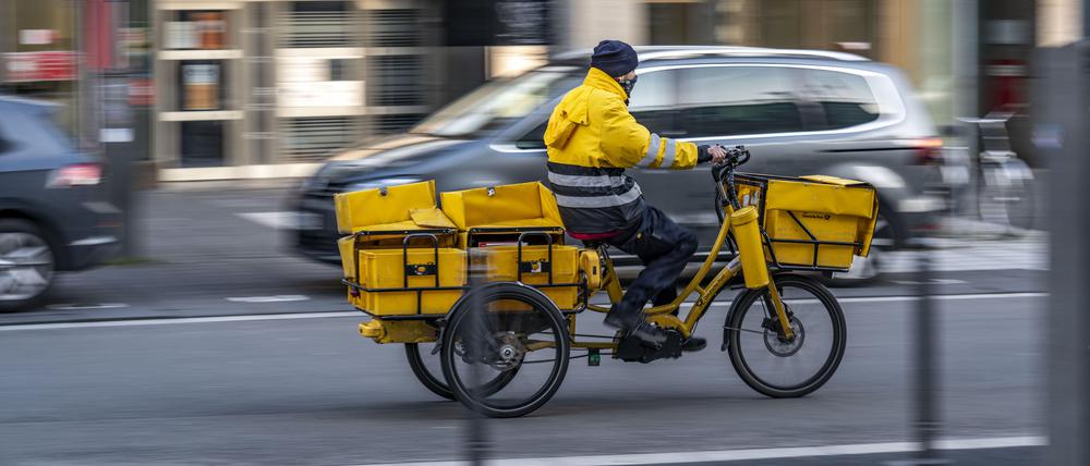 Eine Postbote ist auf einem Dreirad E-Bike unterwegs. 
