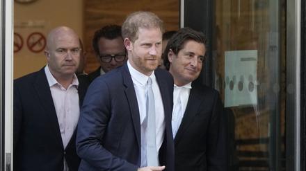 Prinz Harry (M) und sein Anwalt David Sherborne (r) verlassen den High Court nach ihrer Zeugenaussage.