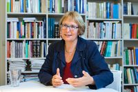 Ulrike Freitag sitzt gestikulierend vor einer Bücherwand. Foto: Rolf Schulten/ZMO