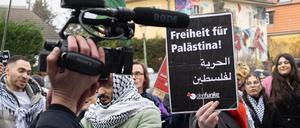 Ein Teilnehmer der propalästinensischen Kundgebung unter dem Motto „Solidarität mit Palästina“ vor der Mensa II an der Freien Universität (FU) hält ein Schild mit der Aufschrift „Freiheit für Palästina“ in der Hand. Die Uni hat Anzeige gegen eine Person der Demo sowie einen Teilnehmer der Gegendemo gestellt. 