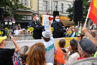 Teilnehmer einer Kundgebung gegen die Corona-Maßnahmen stehen vor dem Reichstag, ein Teilnehmer hält eine Reichsflagge. Foto: Fabian Sommer/dpa