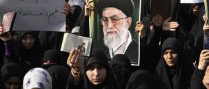Demonstranten halten Kopien des Korans und Porträts des iranischen Obersten Führers Khamenei während eines Protests vor der schwedischen Botschaft. 
