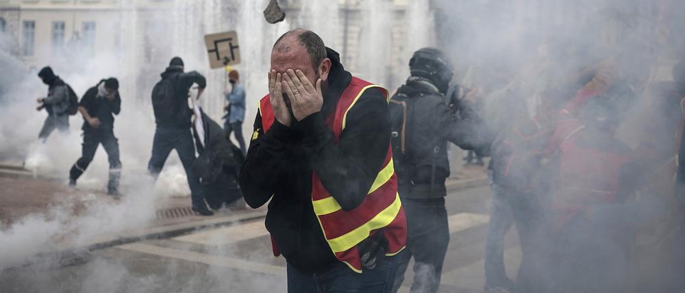 Demonstranten rennen während einer Demonstration durch Tränengas. 
