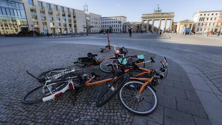 Leihfahrraeder liegen auf einem Haufen vor dem Brandenburger Tor in Berlin.