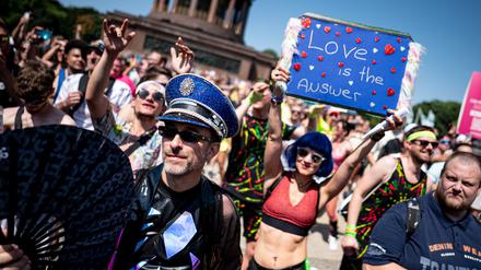 Eine Person feiert im vergangenen Sommer auf der „Rave the Planet“-Technoparade mit einem Plakat mit der Aufschrift „Love is the answer“. 