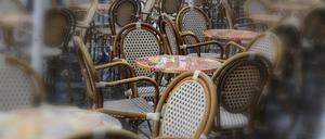 Im Regen stehen leere Tische und Stühle am Sonntag vor Cafes und Restaurants.