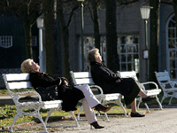 Zwei Rentner sitzen im Schatten des Schlossparks Charlottenburg auf einer Bank. Foto: Ole Spata / dpa