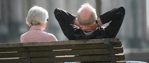 Ein Rentnerpaar sitzt auf einer Bank und sonnt sich. (Symbolbild)