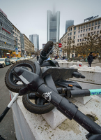 Nicht ausschließlich gut für das Stadtbild: E-Scooter liegen übereinander geschichtet auf einer Betonsperre. Foto: Frank Rumpenhorst/dpa