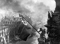 Das Bild zeigt den sowjetischen Soldaten Militon Kantarija aus Georgien, der 1945 die sowjetische Flagge auf dem Reichstag hisst. Foto: Jewgeni Chaldej/Picture Alliance/ dpa