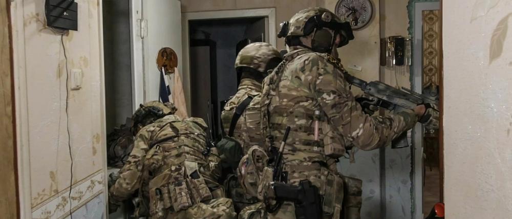 Nach den Explosionen auf der Krim-Brücke nehmen russische Soldaten einen mutmaßlichen Spion fest. 