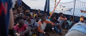 Die von der Seenotrettungsorganisation Sea-Eye herausgegebene Aufnahme zeigt Flüchtlinge an Bord des Seenotrettungsschiffs „Alan Kurdi“ während ein Boot der italienischen Guardia di Finanza vorbei fährt.