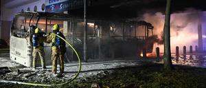 Feuerwehrleute löschen in der Silvesternacht an der Sonnenallee im Bezirk Neukölln einen brennenden Bus, der von Randalierern angezündet wurde.