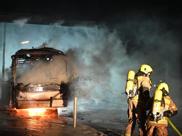 Ausgebrannt: Feuerwehrleute löschen an der Sonnenallee einen Reisebus, der von Unbekannten angezündet worden war.