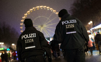 Polizisten beobachten Deutschlands größte Silvesterparty am Brandenburger Tor. Foto: dpa, Ralf Hirschberger