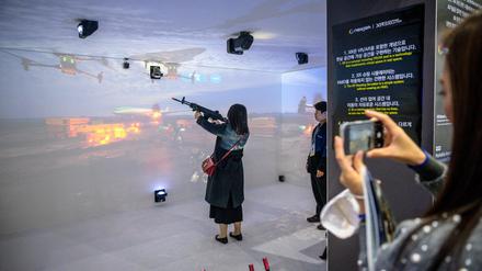 Eine Frau benutzt einen XR-Schießsimulator auf der Seoul International Aerospace and Defense Exhibition (ADEX) in Seongnam, südlich von Seoul, am 18. Oktober 2023.