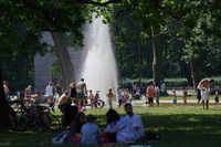 Zahlreiche Menschen suchen bei hochsommerlichen Temperaturen den kühlenden Springbrunnen im Treptower Park auf. (18.06.2022) Foto: Jörg Carstensen/dpa