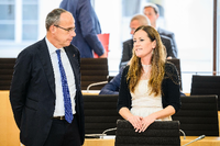 Peter Beuth (CDU), Innenminister von Hessen, spricht mit Janine Wissler (Die Linke), Fraktionsvorsitzende ihrer Partei in Hessen, im Plenarsaal. Foto: Andreas Arnold/dpa