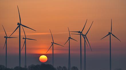 Der Sonnenaufgang ist am frühen Morgen hinter einem Windenergiepark im Landkreis Oder-Spree im Osten des Landes Brandenburg zu sehen.