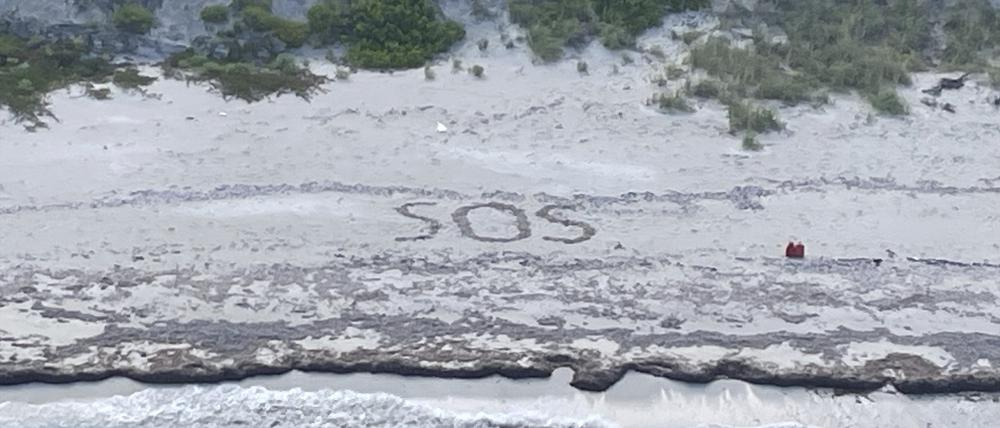 Dieses von der US-Küstenwache zur Verfügung gestellte Foto zeigt die Buchstaben „SOS“, die von einem 64-jährigen Mann auf der Bahamas-Insel Cay Sal in den Sand gezeichnet wurden.