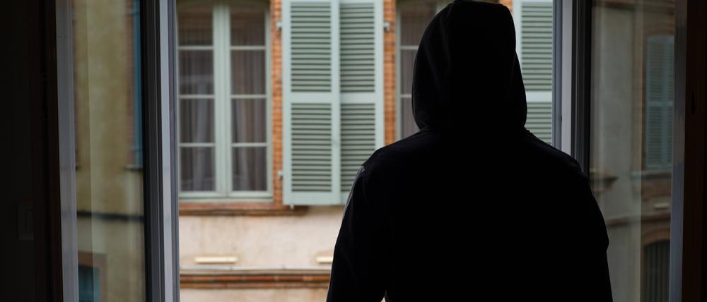 Ein junger Mann mit einer suchtbedingten Depression blickt aus dem Fenster einer Klinik.  
