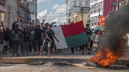 Anhänger der Oppositionsparteien halten eine Nationalflagge, während sie während einer Demonstration vor der bevorstehenden ersten Runde der madagassischen Präsidentschaftswahlen in Antananarivo, Madagaskar, am 11. November 2023 auf Bereitschaftspolizisten zugehen. 