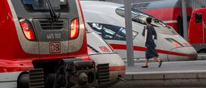 Zugreisende gehen an Zügen der Deutschen Bahn im Münchner Hauptbahnhof vorbei.