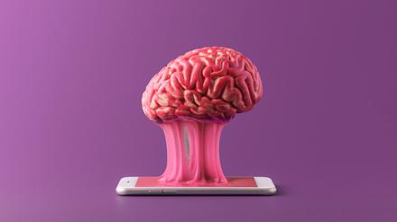The human brain is stuck to a smartphone on a purple background. Concept of a day without gadgets.