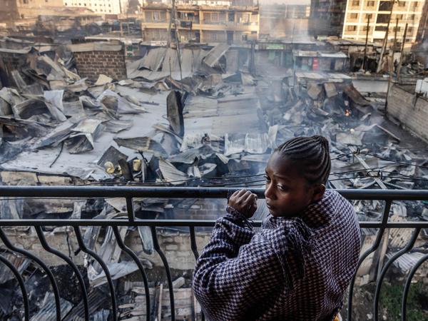 Eine Frau blickt in Nairobi am 2. Februar 2024 nach dem Großbrand von ihrem Balkon auf die schwer beschädigten Häuser.