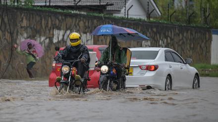Motorbike riders wade through a waterlogged street after heavy rains in Mombasa on November 3, 2023. 