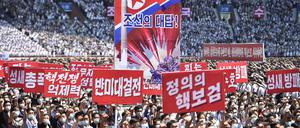 TOPSHOT - In this photo taken on June 25, 2023, residents of Pyongyang hold banners that read "answer of DPRK", "nuclear war deterrent", "anti-US confrontation" and "the nuclear treasured sword of justice" during a mass rally to mark the "Day of Struggle Against US imperialism", on the 73rd anniversary of the three-year Korean War, which began on June 25, 1950, at the Mayday Stadium in Pyongyang. (Photo by KIM Won Jin / AFP)