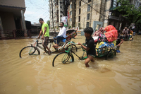 Rikscha-Fahrer kämpfen sich in Sylhet in Bangladesch durch überflutete Straßen. Foto: Mamun Hossan/AFP