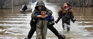 Ein Bild vom 8. April 2024 zeigt, wie Rettungskräfte Bewohner aus dem überfluteten Teil der Stadt Orsk in der russischen Region Orenburg, südöstlich der Südspitze des Uralgebirges, evakuieren. 
