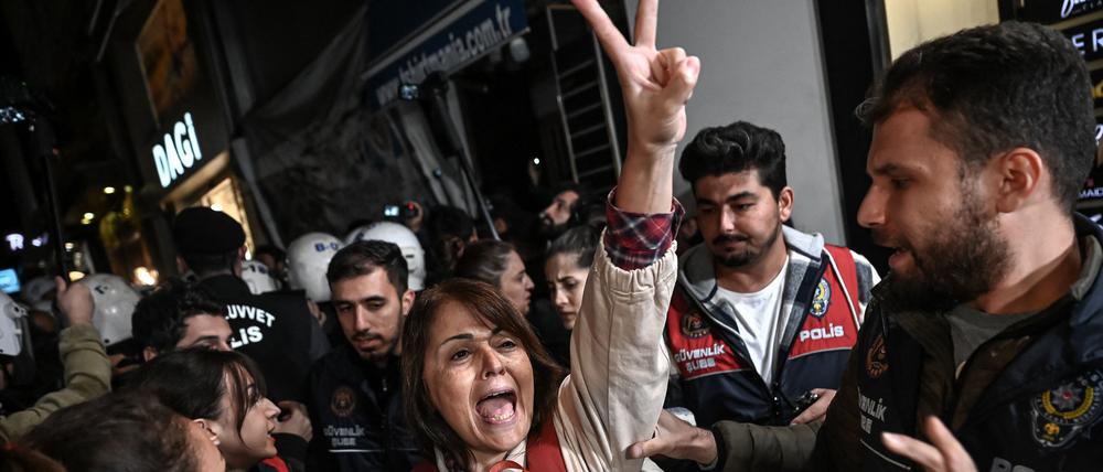 Eine Demonstrantin zeigt ein Victory-Zeichen, als sie während einer Demonstration in Istanbul am 26. Oktober 2022 von türkischen Anti-Riot-Polizisten festgehalten wird, nachdem die Vorsitzende der türkischen Ärztegewerkschaft (TTB), Sebnem Korur Fincanci, verhaftet wurde.