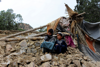 Zwei Jungen vor einem Haus, das bei dem Erbeben zerstört wurde. Foto: dpa/AP/Uncredited