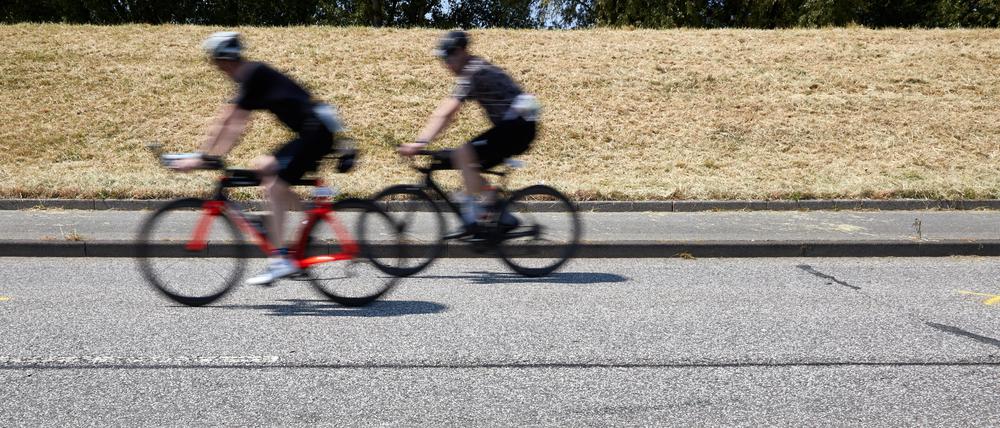 Triathleten fahren auf dem Rad an der Unglückstelle auf dem Gaueter Hauptdeich vorbei.